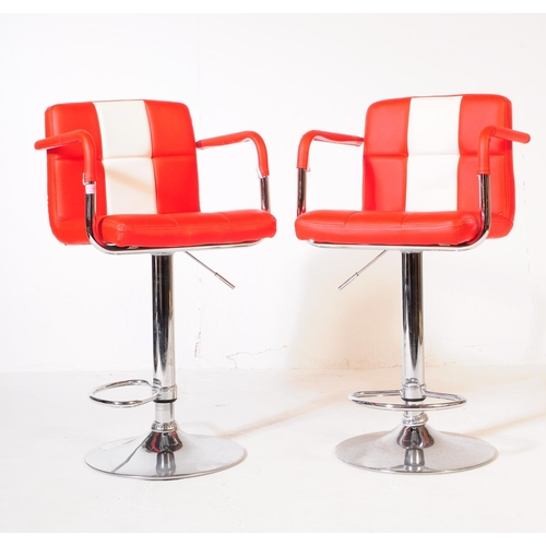 642 - A pair of contemporary red and white vinyl and chrome bar / kitchen breakfast stool chairs. The chai... 