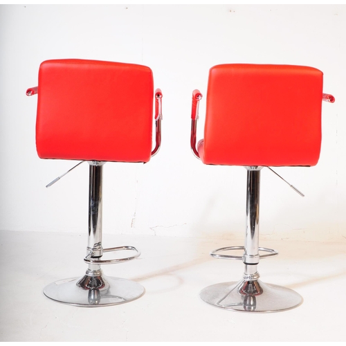 642 - A pair of contemporary red and white vinyl and chrome bar / kitchen breakfast stool chairs. The chai... 