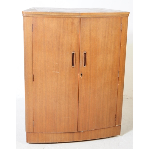 649 - Turnidge of London - A mid 20th century teak cocktail drinks cabinet. With twin hinged doors to fron... 