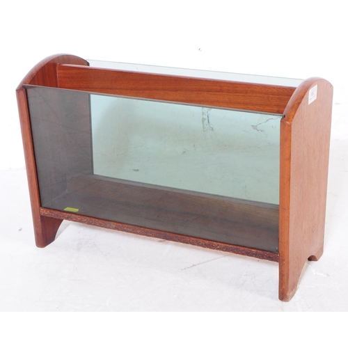 692 - British Modern Design - A mid 20th century teak wood and smoked glass magazine rack alongside anothe... 