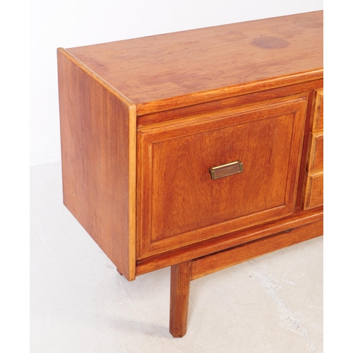 696 - British Modern Design - A mid 20th century teak wood sideboard credenza. The sideboard having a bank... 