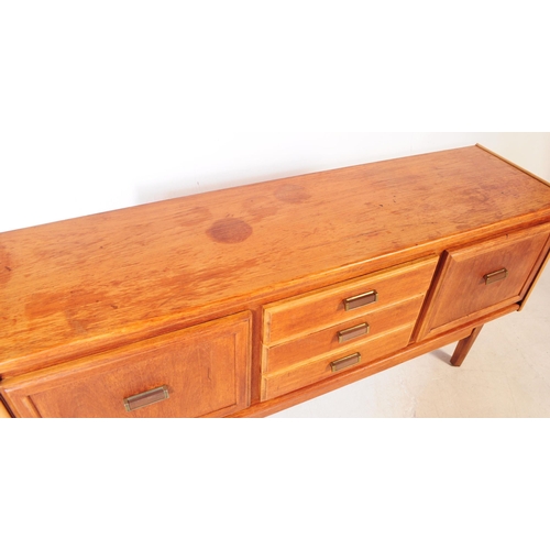 696 - British Modern Design - A mid 20th century teak wood sideboard credenza. The sideboard having a bank... 