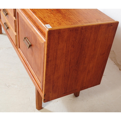 696 - British Modern Design - A mid 20th century teak wood sideboard credenza. The sideboard having a bank... 