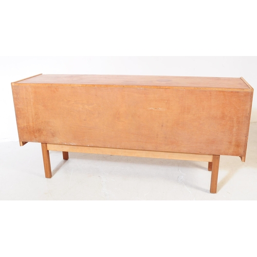 696 - British Modern Design - A mid 20th century teak wood sideboard credenza. The sideboard having a bank... 