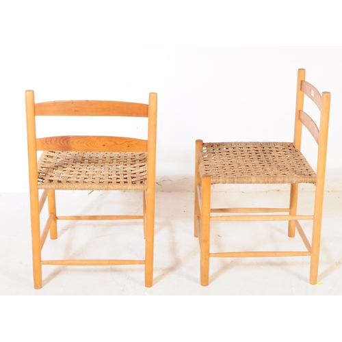 712 - A pair of mid 20th century beech shaker manner dining chairs. The chairs raised on rounded supports,... 