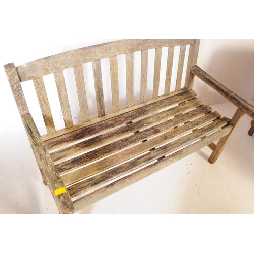 722 - British Modern Design - A late 20th century teak garden bench. Having curved flat vertical slat back... 