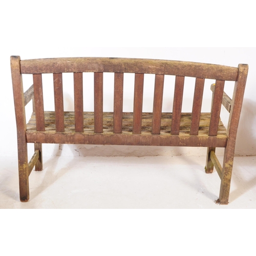 722 - British Modern Design - A late 20th century teak garden bench. Having curved flat vertical slat back... 