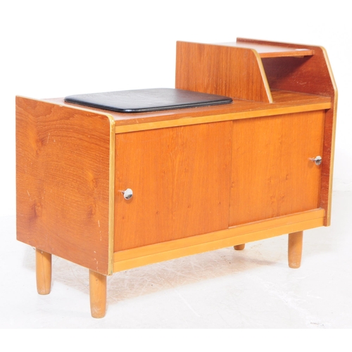 727 - A retro mid 20th century teak veneer telephone table. Rectangular form with raised platform with pig... 