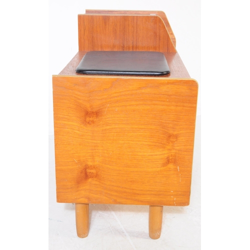 727 - A retro mid 20th century teak veneer telephone table. Rectangular form with raised platform with pig... 