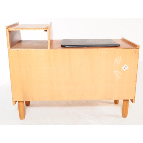 727 - A retro mid 20th century teak veneer telephone table. Rectangular form with raised platform with pig... 