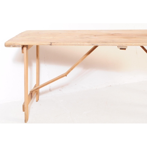 737 - A mid 20th century oak wood trestle folding table and chairs. The table of rectangular form, raised ... 