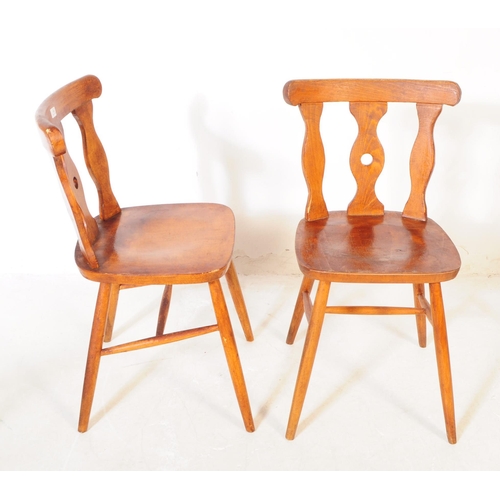 740 - A set of four mid 20th century rustic kitchen bistro dining chairs. Each chair having a shaped centr... 