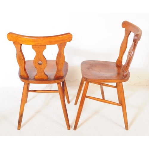 740 - A set of four mid 20th century rustic kitchen bistro dining chairs. Each chair having a shaped centr... 