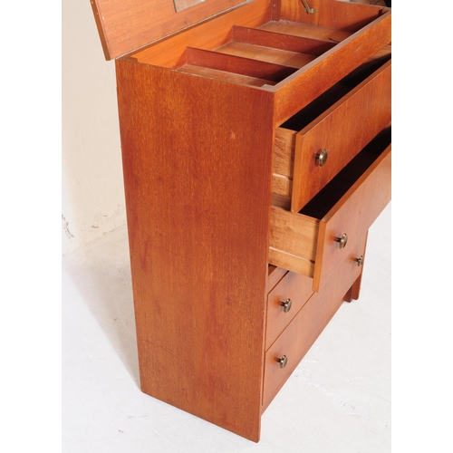 751 - British Modern Design - A mid 20th century teak veneered dressing chest of drawers. The chest of dra... 