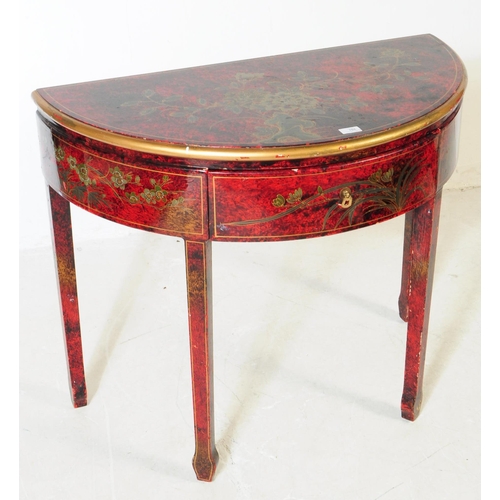 784 - A 20th century chinoiserie style lacquered demi lune console table. The table having hand painted wa... 