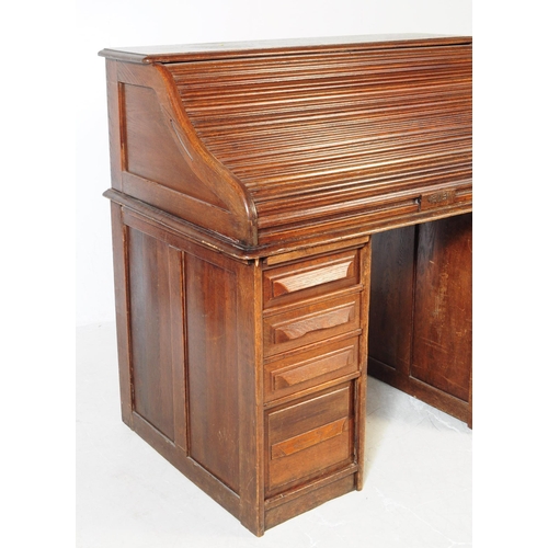 787 - An early 20th century oak tambor roll top desk. The desk raised on two pedestals, each featuring a b... 