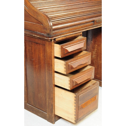 787 - An early 20th century oak tambor roll top desk. The desk raised on two pedestals, each featuring a b... 