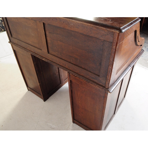 787 - An early 20th century oak tambor roll top desk. The desk raised on two pedestals, each featuring a b... 