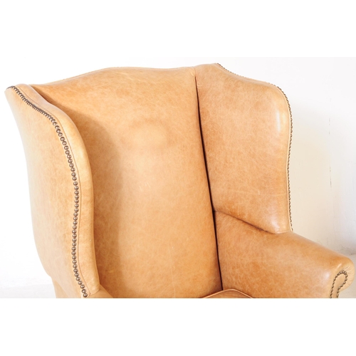 802 - A late Victorian leather fireside lounge wing back armchair. With scrolled elbow rests, stud work to... 