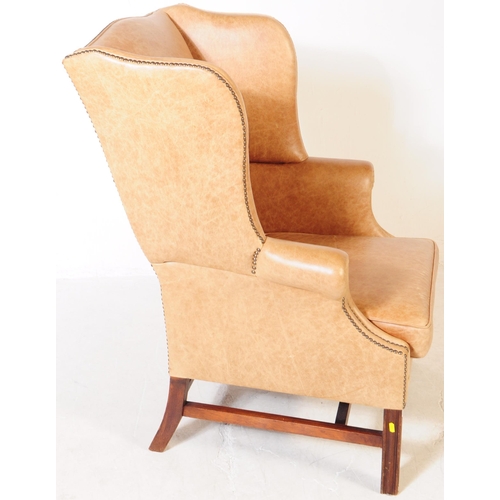 802 - A late Victorian leather fireside lounge wing back armchair. With scrolled elbow rests, stud work to... 