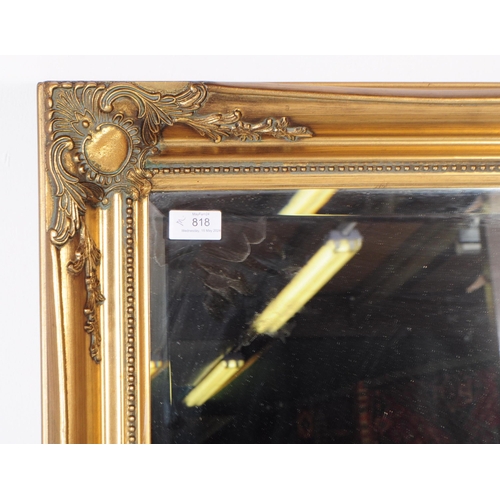 818 - A contemporary overmantle gilt mirror. Rectangular form with spandrel cartouche to corners with furt... 