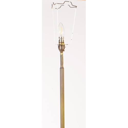 821 - An early 20th century brass and wood floor standing standard lamp. Having reeded central column into... 