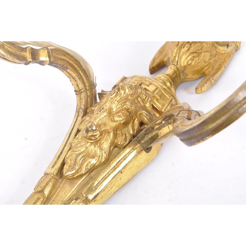 855 - A brass gilded twin branch wall sconce lights with golden ram head to body and vase shaped finial wi... 