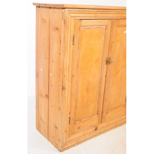 876 - A Victorian 19th century pitch pine school cupboard. Of rectangular form with flared top, twin woode... 