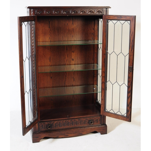 906 - A Jacobean revival oak wood glazed bookcase / display cabinet. The cabinet featuring two doors to fr... 