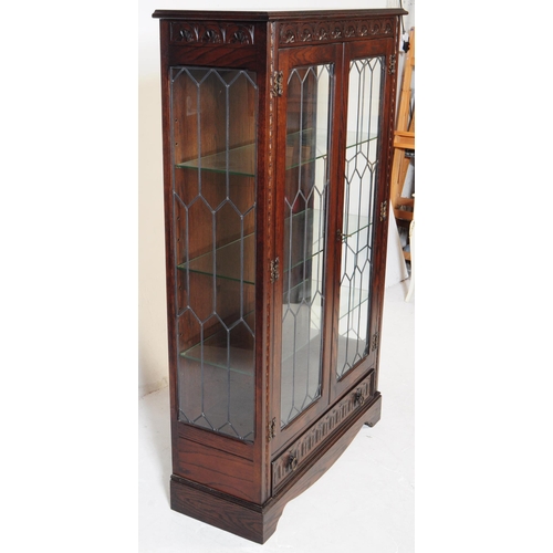 906 - A Jacobean revival oak wood glazed bookcase / display cabinet. The cabinet featuring two doors to fr... 