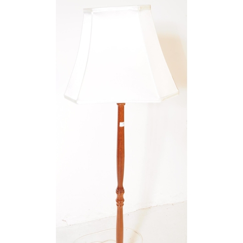 909 - A 20th century turned mahogany floor standing standard lamp. The lamp raised on a rounded base, with... 