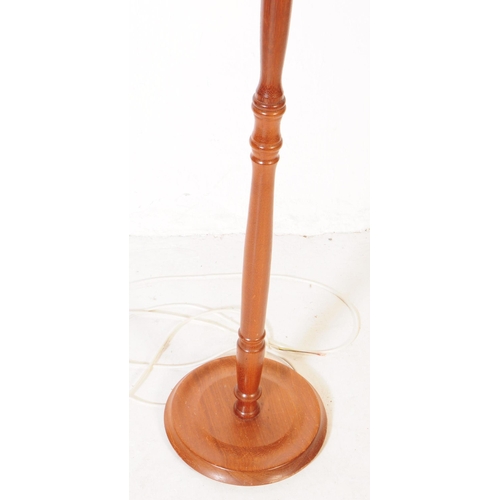 909 - A 20th century turned mahogany floor standing standard lamp. The lamp raised on a rounded base, with... 