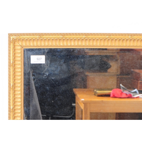 927 - A 20th century giltwood and gesso framed mirror. The mirror having a central rectangular form mirror... 