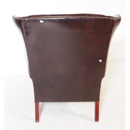 980 - Chesterfield style - A 20th Century brown leather Chesterfield manner wingback armchair. Raised on c... 