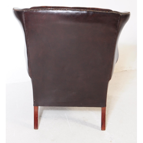 987 - Chesterfield style - A 20th Century brown leather Chesterfield manner wingback armchair. Raised on c... 