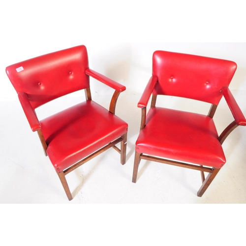 667 - A pair of vintage 20th century red vinyl carver bridge armchairs. Having a back rest on padded cushi... 