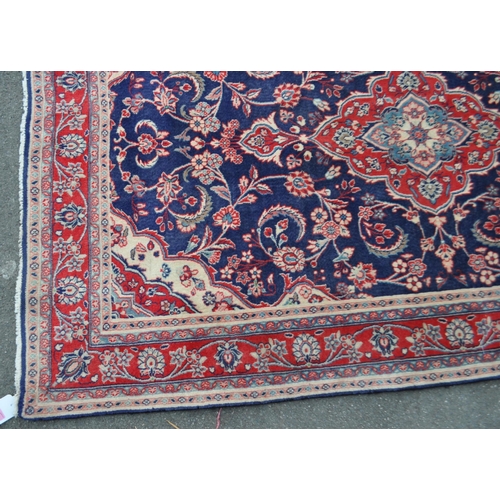 990 - A vintage 20th century North West Persian Sarouk carpet floor rug. Having a red central medallion in... 