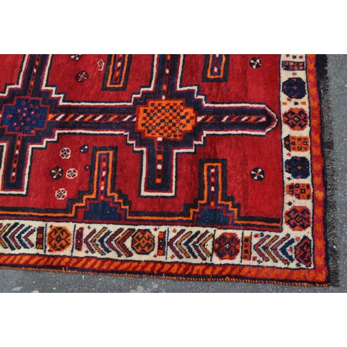 992 - A vintage 20th century South West Persian Lori carpet floor rug. Rectangular form in a red and orang... 