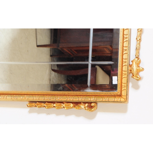 1052 - A 20th Century French style bevelled overmantle mirror of rectangular form having gilt frame with sw... 