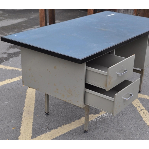 606 - Industrial Interiors - A 20th century industrial metal workshop desk. The desk featuring banks of tw... 