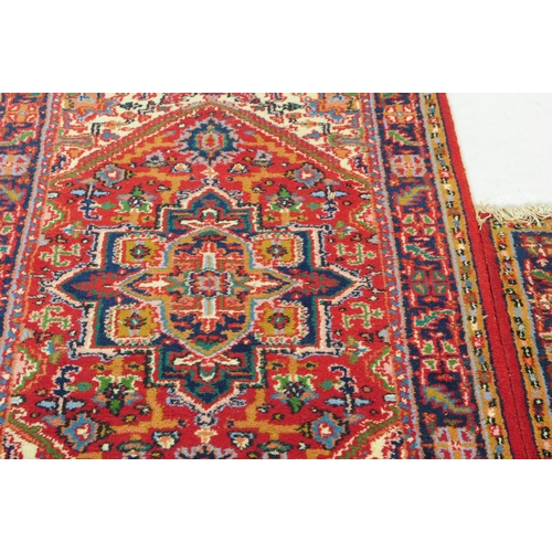 831 - Two late 20th century Persian manner wool rugs. The rugs both having red grounds, featuring large ce... 