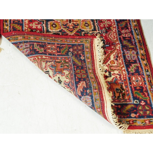 831 - Two late 20th century Persian manner wool rugs. The rugs both having red grounds, featuring large ce... 