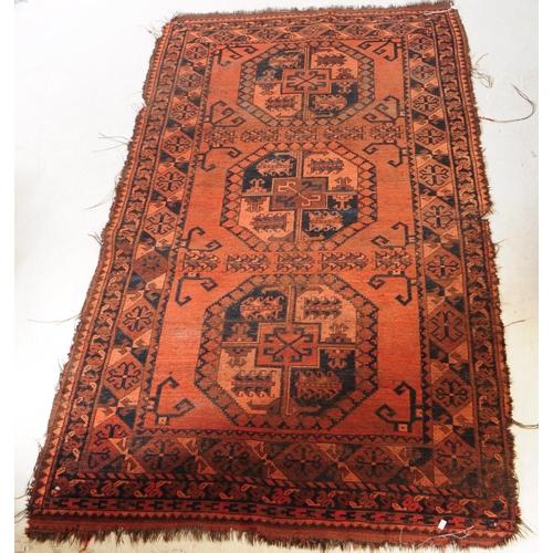 895 - An early 20th century Persian Afghan Ersari manner carpet floor rug. The rug having a red ground wit... 