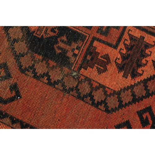 895 - An early 20th century Persian Afghan Ersari manner carpet floor rug. The rug having a red ground wit... 