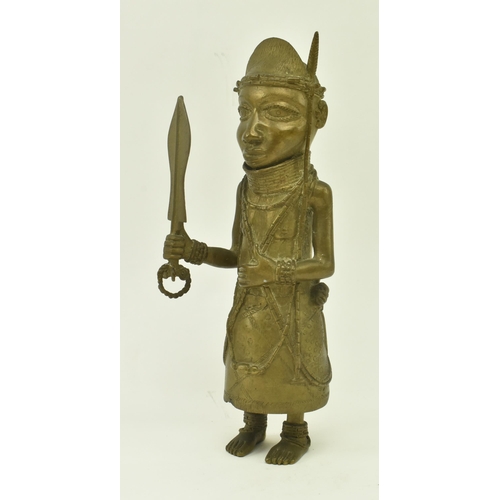 62 - A 20th century African Benin bronze cast figure of a native warrior. The figure wearing a coral bead... 