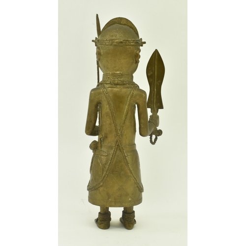 62 - A 20th century African Benin bronze cast figure of a native warrior. The figure wearing a coral bead... 