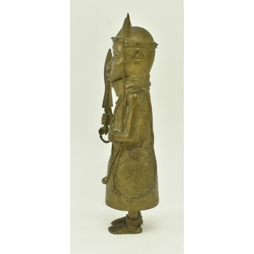 62 - A 20th century African Benin bronze cast figure of a native warrior. The figure wearing a coral bead... 