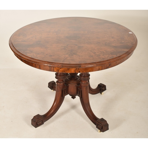 608 - A 19th century High Victorian walnut oval tilt top loo / breakfast table. The table being raised on ... 