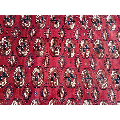 611 - A large 20th century hand knotted Persian Islamic carpet floor rug. The rug having a deep red ground... 