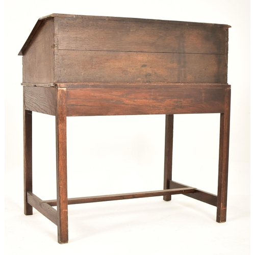 401 - An 18th century oak wood clerk's writing desk. The desk having a slope top with gallery front to hol... 